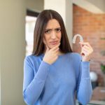 holding clear aligners and wondering about Invisalign discomfort